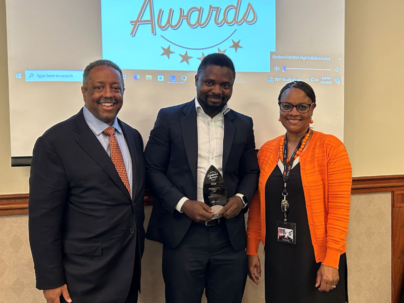 Student stands with award.