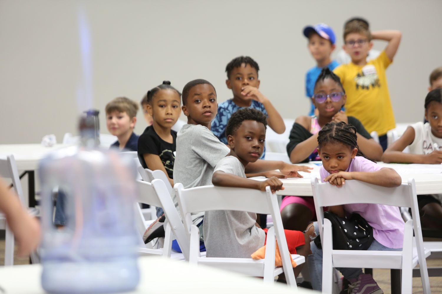 STEM camp students watch an experiment demonstration.