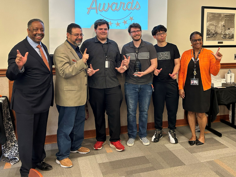 Student stand holding their award.