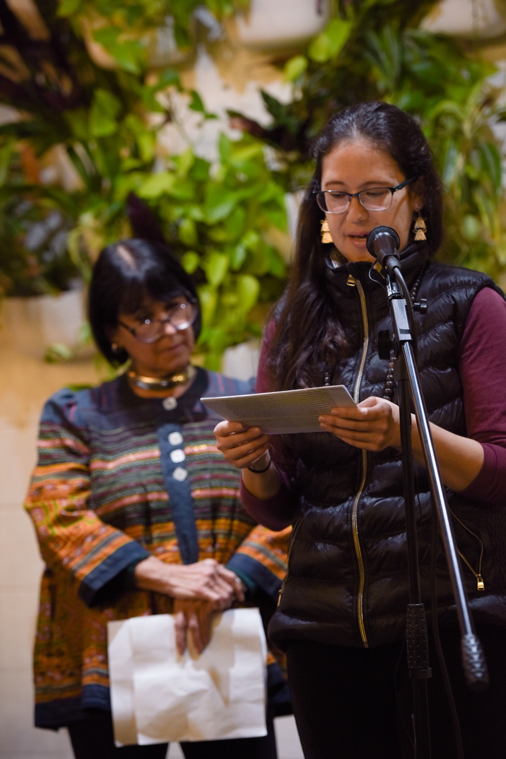 Two speakers stand at microphone stand during a local Live Lit night
