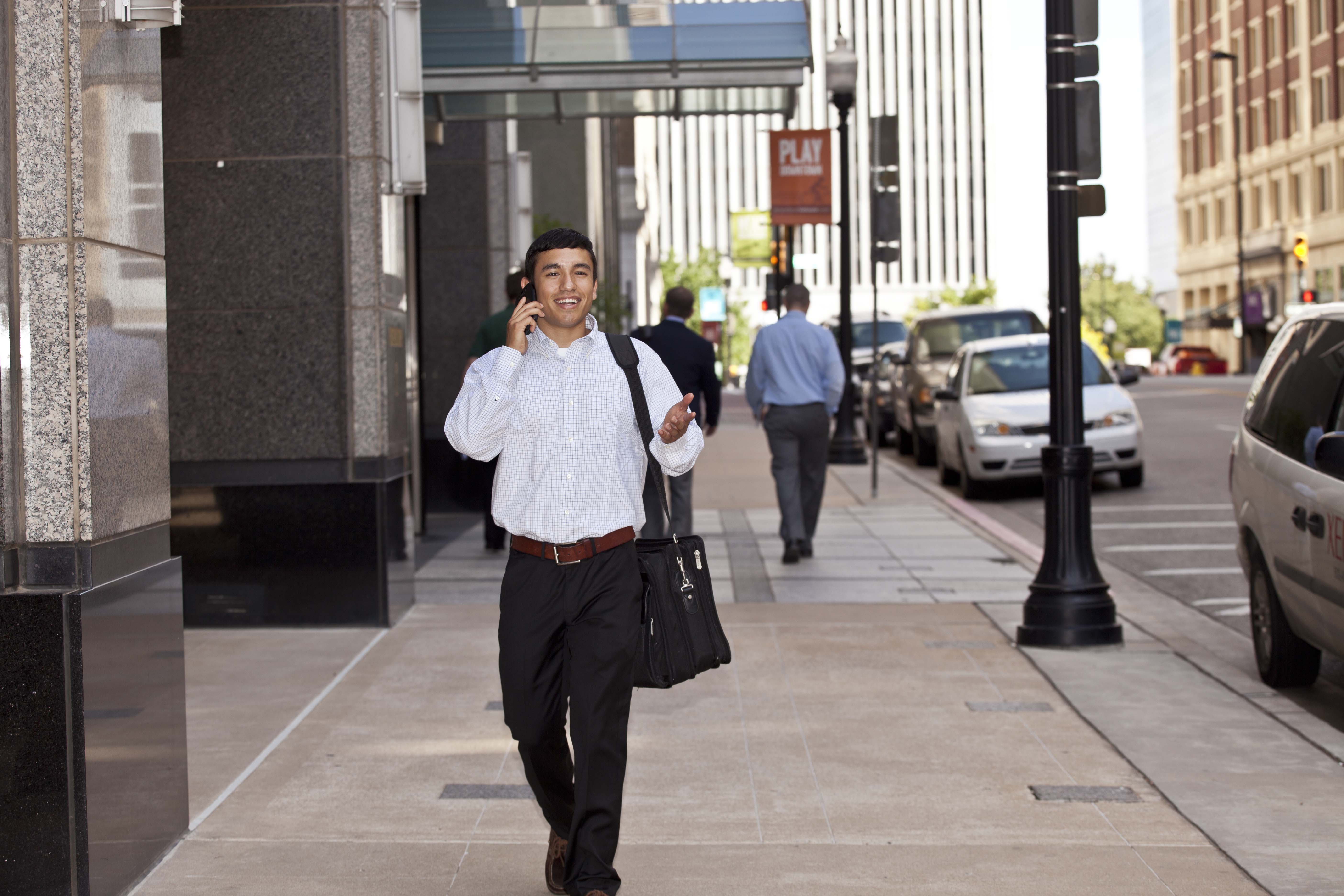 Man walking downtown talking on cell phone