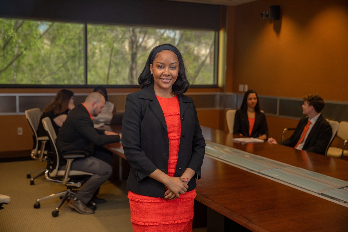 woman stands in front of conference room table