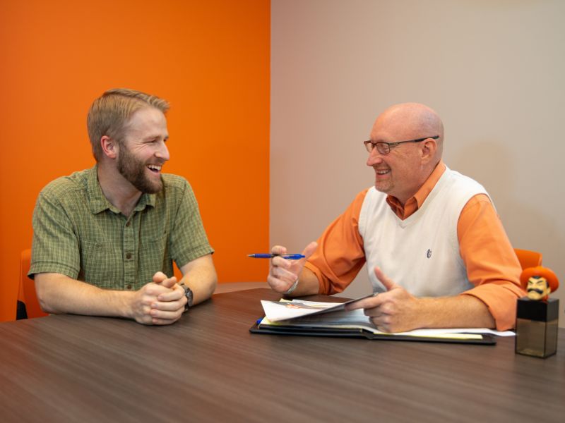 student meeting with counselor in orange and white office