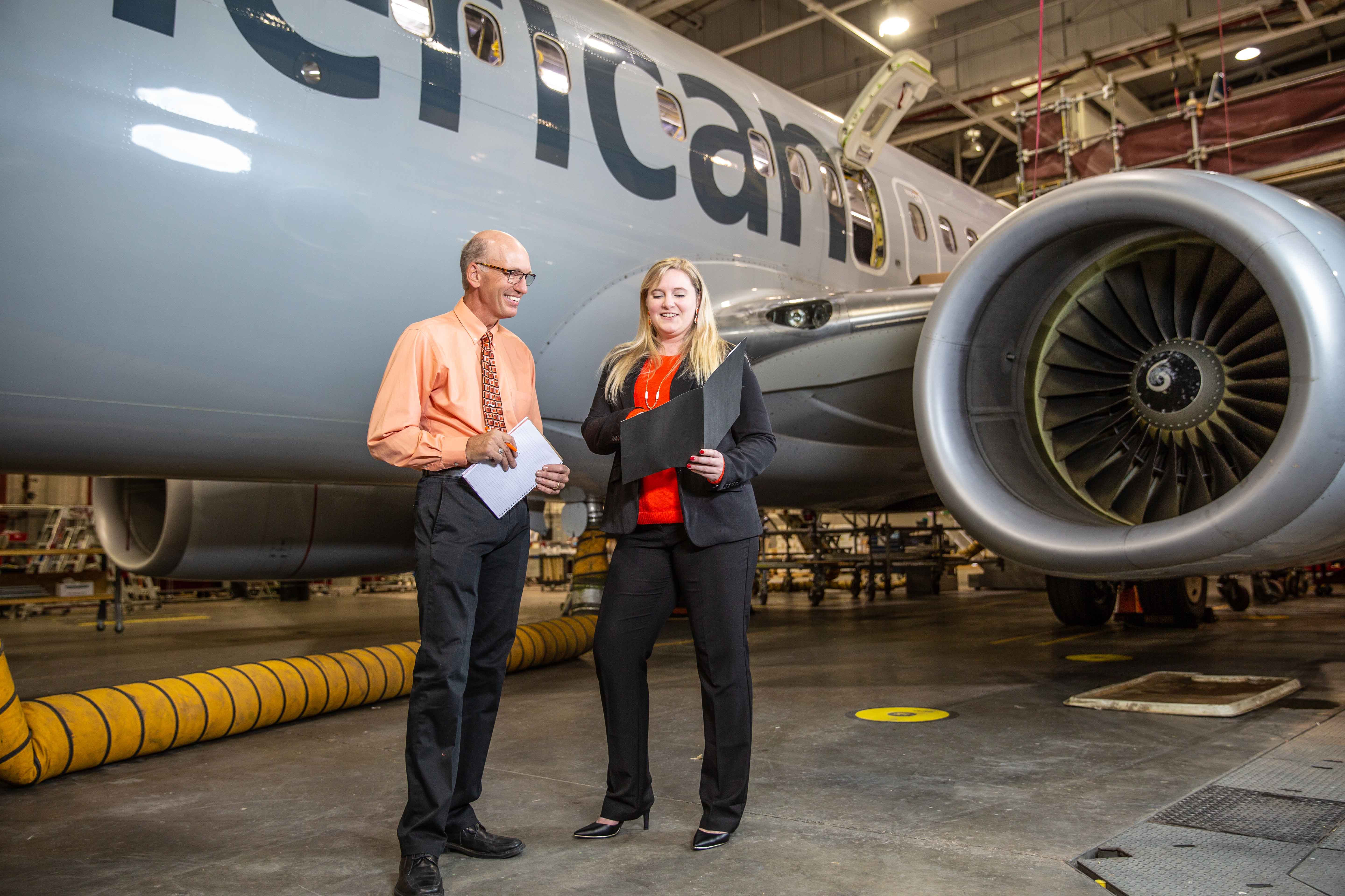 Two students working in an airline hanger