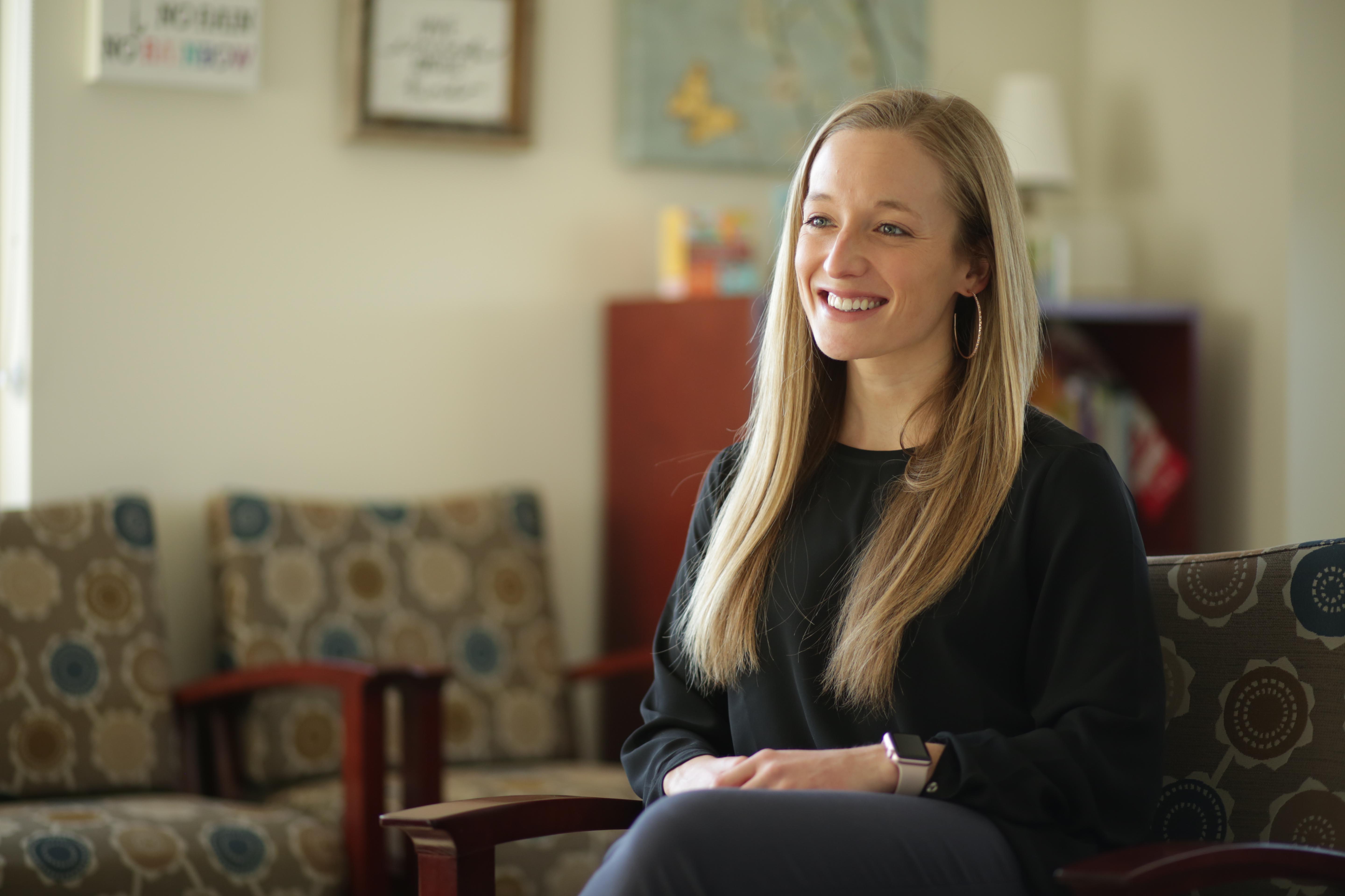 woman smiles sitting in  armchair