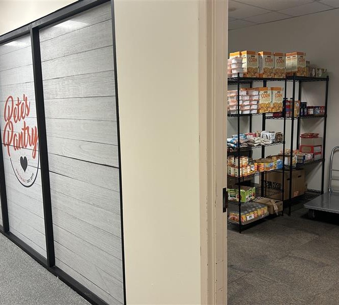 view from doorway looking into pantry with shelves of non perishable food